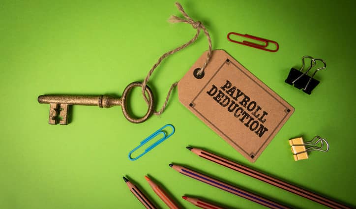 Payroll Deduction. Golden key with price tag on green office table.